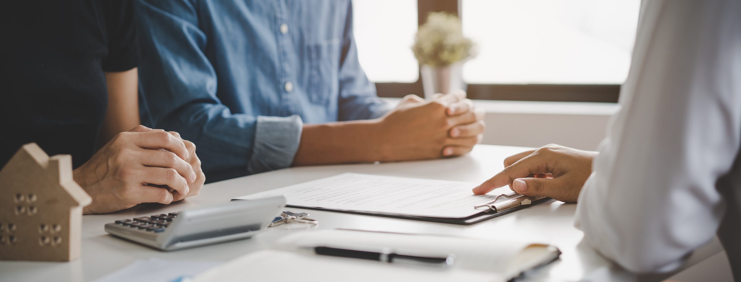 financial investor advisory. Close up hand pointing at contract and document while sitting together with young couple at the desk in office